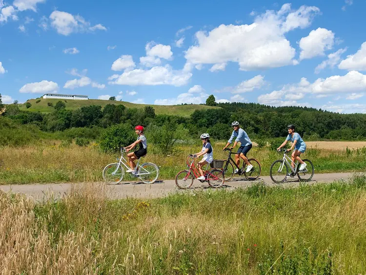 Foto: Staatliche Schlösser und Gärten Baden-Württemberg, Niels Schubert Radelnde Familie mit Heuneburg im Hintergrund